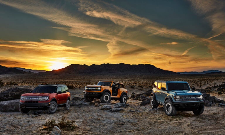Three 2024 Ford Broncos parked in desert at sunset